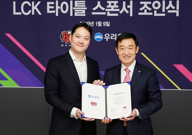 박준규 라이엇 게임즈 한국대표(왼쪽)과 정채봉 우리은행 부문장이 9일 진행된 LCK 타이틀 스폰서 조인식에서 기념촬영을 하고 있다. [라이엇 게임즈]