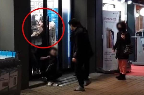 지난 13일 오후 7시쯤 ‘암사역 칼부림’ 피의자 한씨가 칼을 들고 한 매장 앞에 앉아있는 박씨를 위협하고 있다. 매장 내부에 있는 사람들이 출입문을 붙잡고 한씨가 들어오지 못하게 막고 있다. /유튜브 캡처