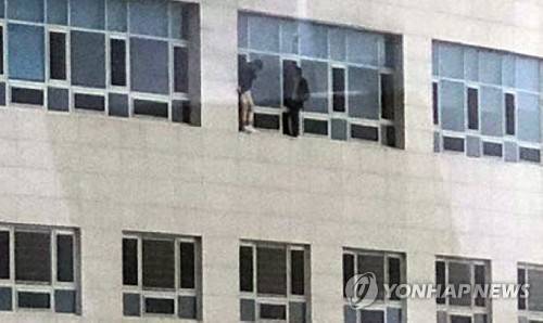 호텔 꼭대기서 구조 대기 중인 시민 (천안=연합뉴스) 14일 오후 충남 천안 라마다 앙코르 호텔에서 불이 나 시민 2명이 꼭대기 층 창문 밖 난간을 밟고 올라선 채 위태롭게 구조 손길을 기다리고 있다. 2019.1.14 [독자 김수영 씨 제공] walden@yna.co.kr