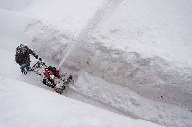 14일(현지시간) 스위스 다보스 라렛에서 한 남성이 눈을 치워 길을 만들고 있다. 사진=AP/뉴시스