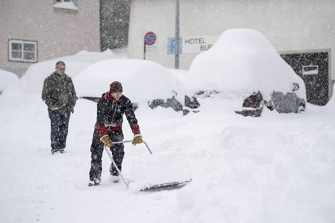 폭설이 내린 13일(현지시간) 스위스 중부 호스펜탈 마을에서 주민들이 눈을 치우고 있다. 사진=AP/뉴시스