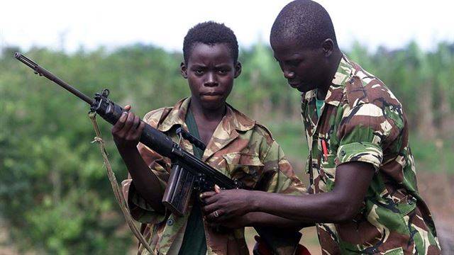 지난 2000년 5월 시에라리온 군의 14살 소년병 아부 카마라(왼쪽)가 수도 프리타운에서 동쪽으로 약 55km 거리에 있는 마시아카 인근의 한 마을을 지키던 중, 선임 병사로부터 자동 소총을 다루는 법을 배우고 있다. 마시아카=AP 연합뉴스 자료사진
