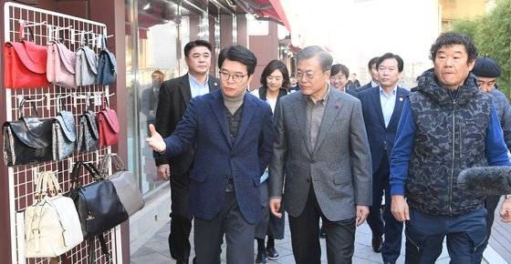문재인 대통령(가운데)이 3일 서울 성동구 성수 수제화 희망플렛폼을 방문해 수제화 거리를 돌아보며 설명을 듣고 있다. [청와대사진기자단]