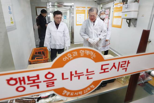 문재인 대통령이 1일 오전 서울 관악구 행복도시락 사회적협동조합 관악센터에서 최영남 나눔공동체 대표와 함께 도시락 포장을 하고 있다. [사진 청와대 ]