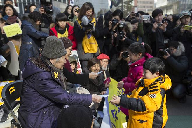 제1217차 일본군 ‘위안부' 문제해결을 위한 정기 수요시위가 열린 2016년 2월10일 낮 서울 종로구 주한일본대사관 앞에서 어린이들이 길원옥, 김복동 할머니에게 세배를 한 뒤 세뱃돈을 받고 있다. 김성광 기자 flysg2@hani.co.kr