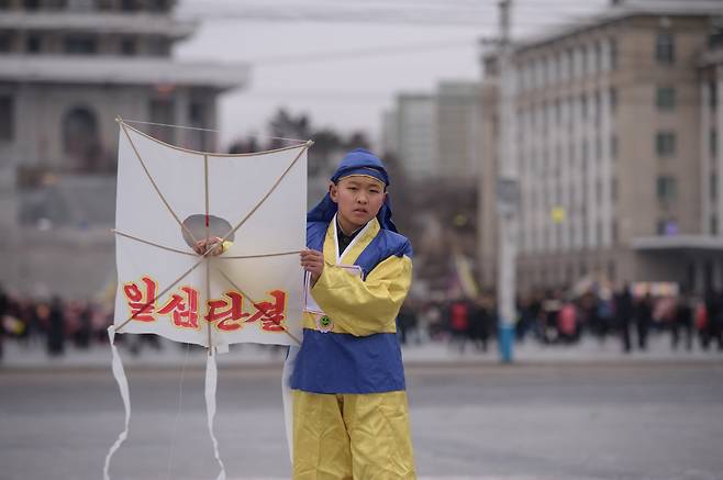 김일성광장에서 만난 한 전통복장의 소년이 일심단결이라고 쓴 방패연을 들고 있다.[AFP=연합뉴스]