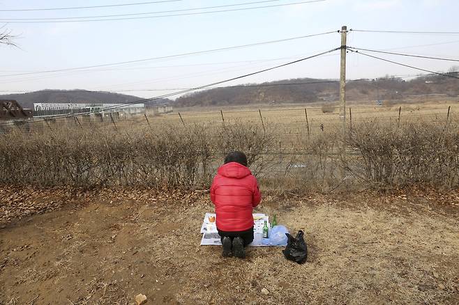 외신 기자의 눈에 비친 한국의 설은 쓸쓸하다. 5일 한 탈북민이 파주 임진각 분단의 철조망 앞에서 북녁을 향해 제사를 지내고 있다.[AP=연합뉴스]