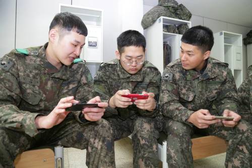 육군 청성부대 소속 장병들이 지난달 31일 부대 생활관에서 휴대전화를 사용하며 일과 후의 여유를 즐기고 있다. 육군 제공