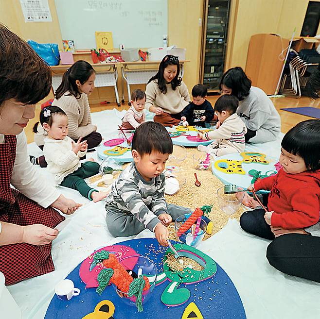 서울 이마트 성수점 문화센터에서 부모와 아이들이 곡물을 이용해 감각을 키우는 '북이랑 놀이랑'을 수강하는 모습. / 이마트