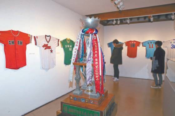1990년대까지 매년 우승한 팀의 리본이 달려있는 프로야구 대형 우승 트로피와 각 팀 유니폼. [최정동 기자]