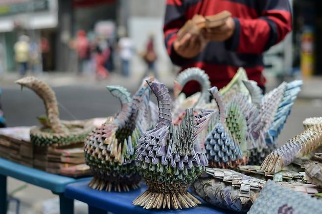 콜롬비아의 국경도시 쿠쿠타에서 베네수엘라 볼리바르 지폐로 만든 새 등 공예품이 팔리고 있다.[AFP=연합뉴스]