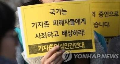2017년 1월 서울 서초구 서울중앙지방법원 앞에서 열린 '한국 내 기지촌 미군 위안부 국가손해배상청구 소송 1심 판결에 대한 기자회견'에서 참석자가 사죄 촉구 관련 피켓을 들고 있다. [연합뉴스]