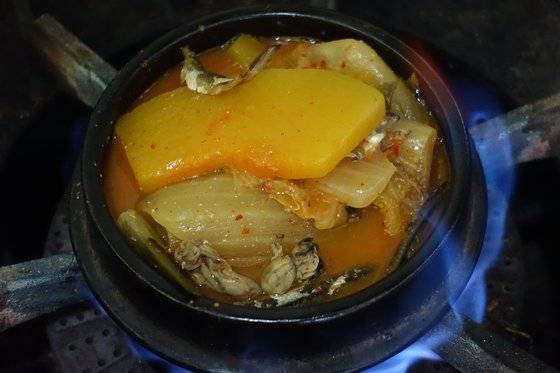 뚝배기에 게국지찌개를 안쳐 끓이고 있다. 굵은 배추 줄기, 늙은 호박, 알이 작은 굴과 국물 멸치가 보인다. 음식점에서는 한 번에 많이 끓여 두고 손님이 오면 덜어서 데워준다. 예전에는 가마솥에 밥 안칠 때 찌개 뚝배기를 함께 넣고 쪄서 먹었다.