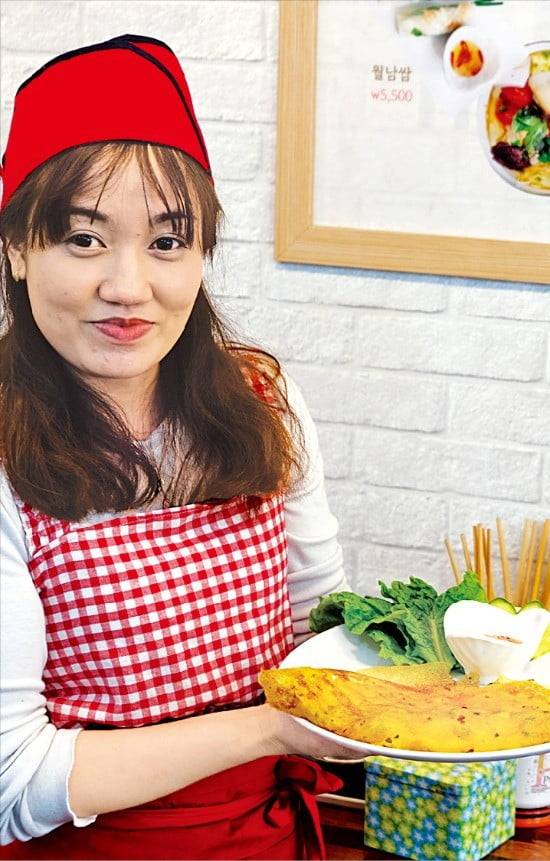 수유시장에서 ‘맘쌀국수’를 운영하는 응우옌투흐엉 씨가 베트남식 부침개 반쎄오를 들어 보이고 있다.