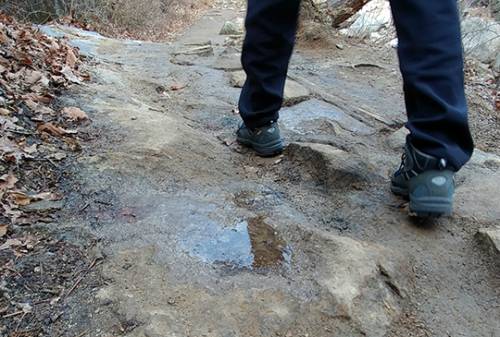 한 등산객이 얼음이 언 구간을 지나고 있다. 노면에 남아있는 빙판으로 인한 안전사고에 각별한 주의가 필요하다.