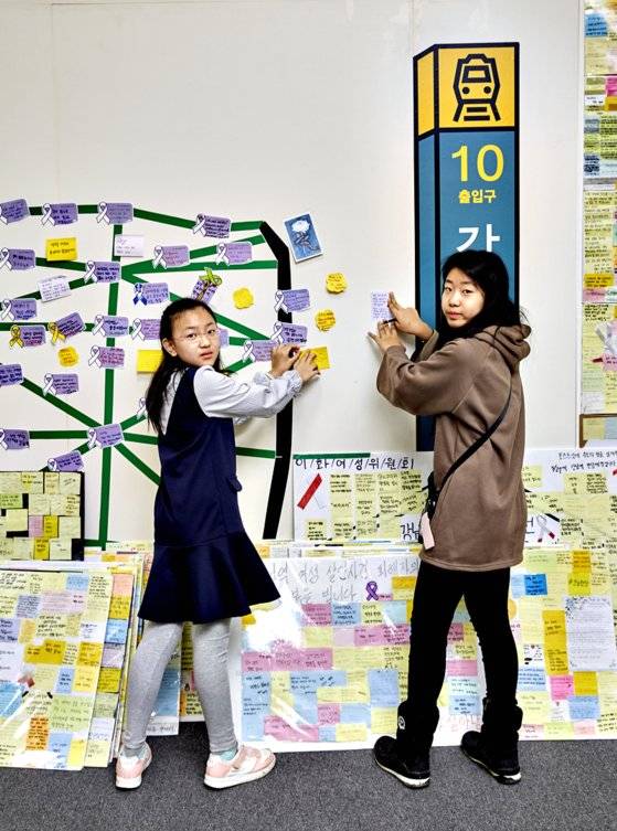 박수연(왼쪽) 학생모델·노효은 학생기자가 '기억존: 강남역 인근 살해사건' 코너 벽면에 다른 방문객들이 남긴 문구도 확인하고 자신들의 의견도 적어 붙였다.