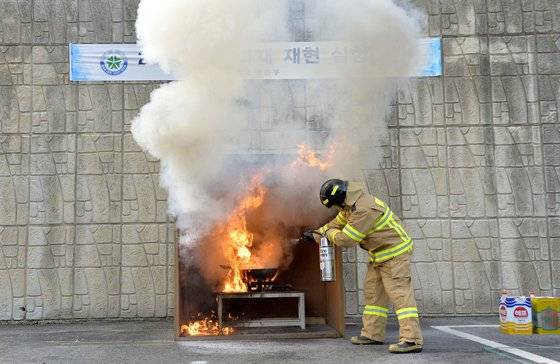 최근 음식점과 가정의 주방에서 부주의로 인한 화재가 날로 증가하고 있는 가운데 6일 대전 119시민체험센터에서 화재 발생시 물과 분말소화기, K급소화기 진압 시연을 실시했다. 이날 대전 소방본부 주최로 열린 식용유 화재를 가상한 진압 실험에서 소방관이 물과 분말소화기, K급소화기를 차례로 이용, 불을 끄고 있다. 초기 화재진압에 사용한 물은 오히려 불을 더 키웠고, 분말소화기도 재 힘을 발휘하지 못했으나, K급소화기는 곧바로 진화에 성공했다. 주방화재 진화에 적합한 K급소화기는 지난 2017년 6월부터 음식점과 다중이용시설, 호텔, 기숙사 등의 주방에 1대 이상 의무적으로 배치해야 한다.김성태/2019.03.06.