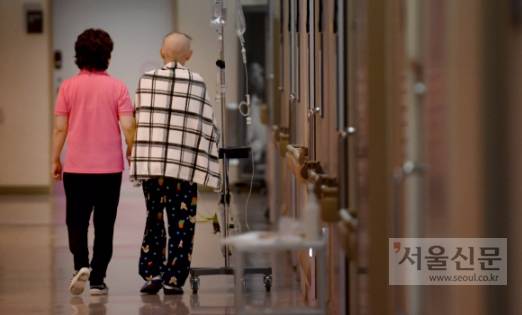 지난 1월 25일 가톨릭대 서울성모병원에서 간병인 김진옥씨가 말기암으로 투병 중인 권진숙(오른쪽) 환자의 손을 꼭 잡고 호스피스 병동을 거닐고 있다. 간병인과 환자로 만난 두 사람은 동갑내기로 친구가 됐다. 박지환 기자 popocar@seoul.co.kr