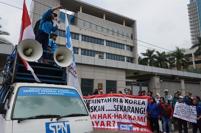 ㈜에스카베(SKB) 노동자들이 14일 자카르타 시내 주인도네시아 한국 대사관 앞에서 ‘인도네시아와 한국 정부는 언제 내 월급을 돌려줄 것인가’라는 문구를 들고 미지급 임금 문제 해결을 촉구하는 집회를 열고 있다. 자카르타=고찬유 특파원