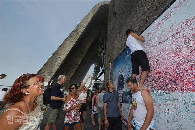 한 여행객이 리우데자네이루의 팡지아수카르의 낙서판에 기념문구를 써넣고 있다.