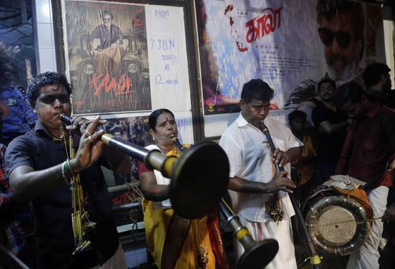 지난해 7월 7일, 인도 뭄바이의 한 영화관에서 인도 영화계의 수퍼스타 라지니칸트가 출연한 신작 영화 개봉에 맞춰 극장 안에서 음악을 연주하고 있다. [AP=연합뉴스]
