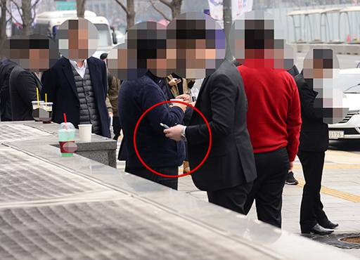 지난 20일 서울 종로구 광화문 인근 보행로. 담배를 입에 문 흡연자들이 삼삼오오 모여 피우고 있다.