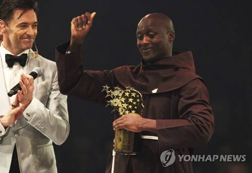 24일 국제교사상을 받고 환호하는 피터 타비치(오른쪽)와 사회를 맡은 휴 잭맨 [AP=연합뉴스]