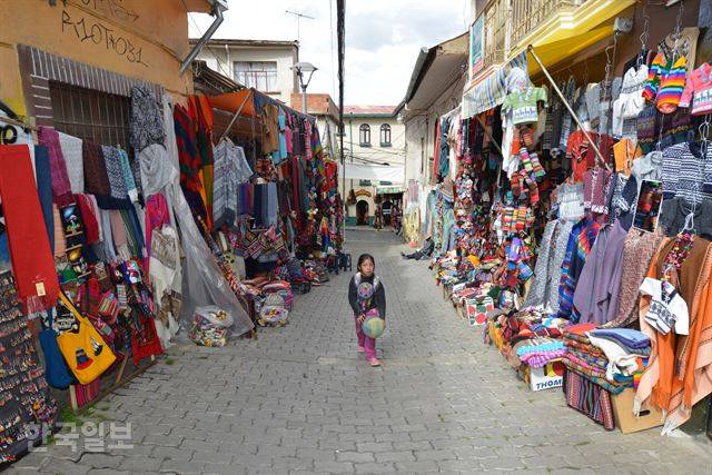 한 어린이가 볼리비아의 수도 라파스의 기념품 골목을 걷고 있다.