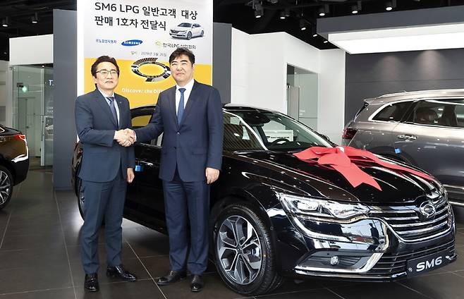김태준 르노삼성 영업본부 상무(사왼쪽)와 국내 1호 LPG 일반판매 고객인 이상범 한국LPG산업협회 회장이 1호차 전달식 진행 후 기념사진을 찍고 있다. 르노삼성 제공