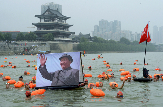 후난성 창사의 창장강에서 이 지역 출신인 마오쩌둥의 초상화를 들고 수영하는 사람들. REUTERS