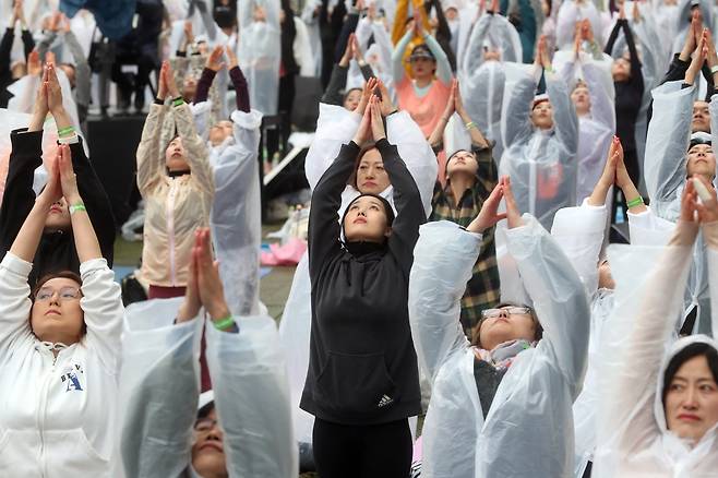 롯데백화점은 14일 창립 40주년을 기념해 전세계에서 가장 큰 요가행사인 '요가 말라 프로젝트'를 유통업계 최초로 개최했다. 이날 비가 내리는 가운데 500여명의 요가 애호가들이 롯데백화점 잠실점 월드파크에서 '108 수리야나마스카라'를 하고 있다. 최정동 기자