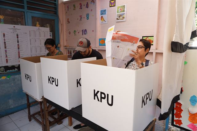 17일 인도네시아 자카르타 대선 투표소에서 시민들이 커다란 투표용지를 펼치며 기표하고 있다. 자카르타=고찬유 특파원