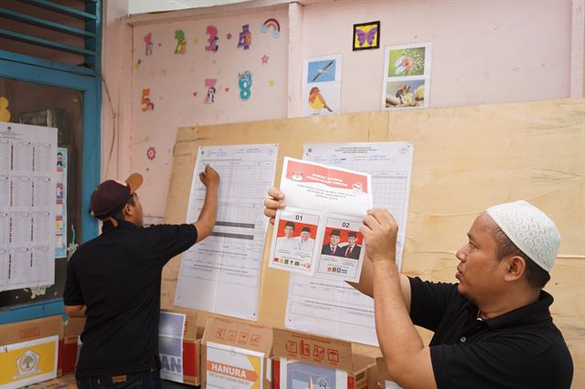 인도네시아의 선거 개표는 한 사람이 기표된 투표용지를 사람들에게 보여주면, 사람들이 뚫린 기호를 말하고 다른 한 사람이 현황 종이에 막대를 표시하는 식으로 진행됐다. 자카르타=고찬유 특파원 2019-04-17(한국일보)