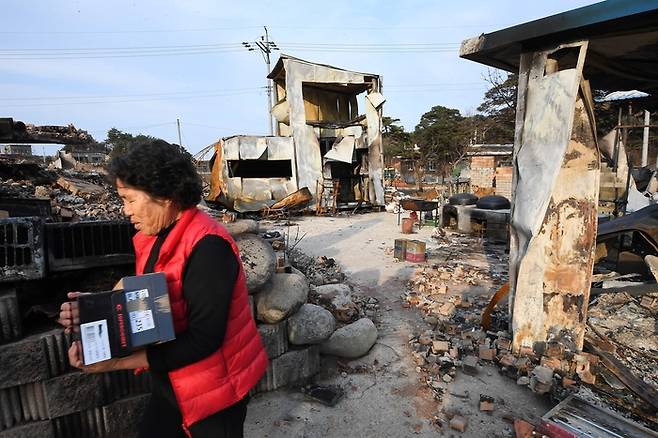 화마가 휩쓸고 간 후 폐허가 된 강원 고성군 토성면 인흥리 마을에 한 주민이 구호품을 받아 집으로 향하고 있다.