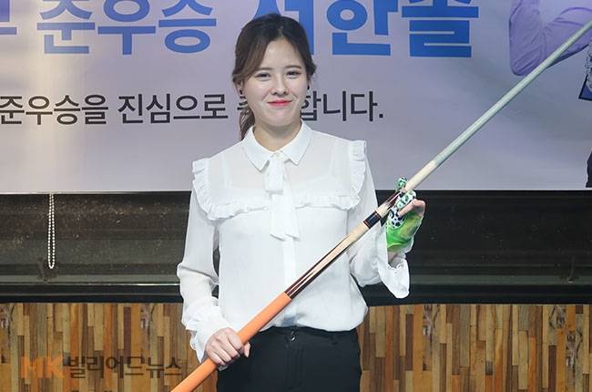 서한솔이 큐를 잡고 카메라를 향해 포즈를 취하고 있다.