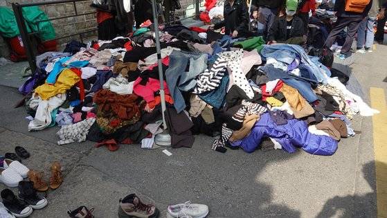 산더미처럼 쌓아 놓은 구제 옷가지에서 옷을 고르고 입어보는 사람들의 모습을 쉽게 볼 수 있다.