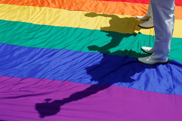 대만 입법원에서 통과시킨 동성결혼 특별법에 대한 법적 효력이 발효된 24일(현지시간) 타이페이에서 혼인신고를 마친 동성부부가 대형 무지개 깃발 위를 걷고 있다. 대만은 지난 17일 아시아  최초로 동성 결혼을 허용하는 특별법안을 통과시켰다. 로이터 연합뉴스