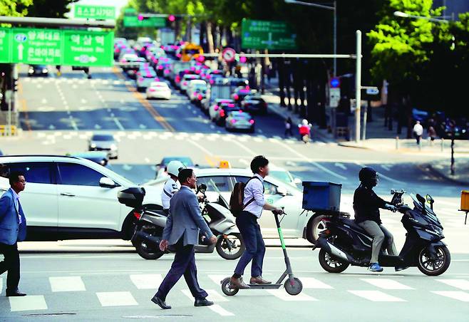 공유형 퍼스널모빌리티 서비스로 대여한 전통킥보드를 탄 시민이 23일 오후 서울 강남구 테헤란로에서 건널목을 건너고 있다. 백소아 기자 thanks@hani.co.kr