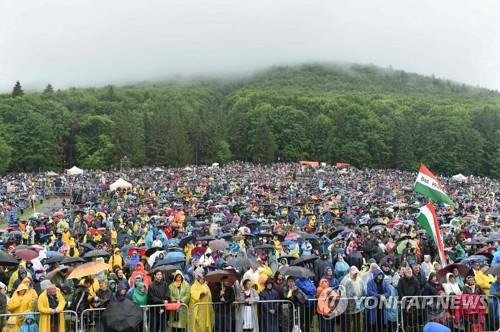 (AFP=연합뉴스) 루마니아에서 유명한 가톨릭 성지인 칙쇼묘의 '성모 마리아 성지'에서 1일(현지시간) 비를 맞으며 교황 도착을 기다리는 가톨릭 신자들.