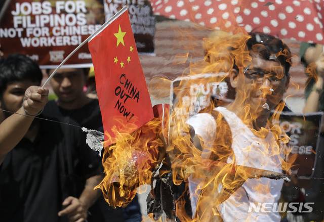 【마닐라=AP/뉴시스】필리핀 시민들이 18일 마닐라 리잘 공원에서 중국 어선이 필리핀 어선을 들이받고 도주한 사건을 비난하는 의미에서 중국 국기를 불태우고 있다. 2019.06.18.