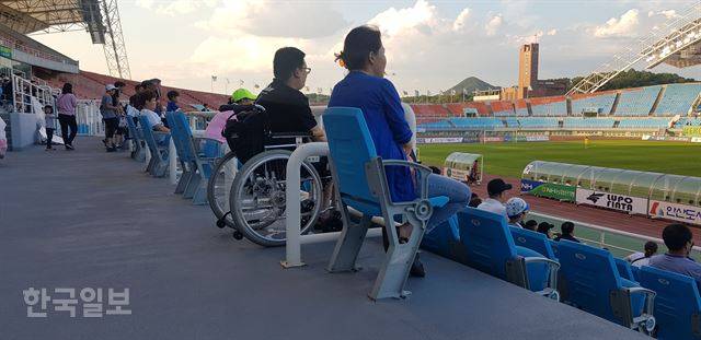 지난달 22일 K리그2 안산과 부산의 경기를 관전하기 위해 경기장을 찾은 강병의(맨 오른쪽)씨와 지영근(30)씨가 경기를 관전하고 있다. 왼쪽엔 대부분 비장애인 관중들이 앉아있다. 안산=김형준 기자