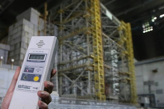 한 사람이 새롭게 설치된 체르노빌 원전 철제 아치형 방호 덮개 내부에서 방사선을 측정하고 있다. 우크라이나는 10일(현지시간) 방호 덮개 운영에 들어갔다. [TASS=연합뉴스]