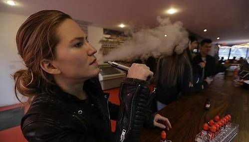 전자담배를 이용해 니코틴을 흡입하고 수중기를 내뿜는 ‘신종 흡연’인 베이핑이 최근 흡연자들의 새로운 트렌드가 되면서 국내 일부 카페가 ‘베이핑 룸’을 설치, 운영 중이다. 베이핑을 통해 전자담배를 즐기고 있는 한 여성. [AP]