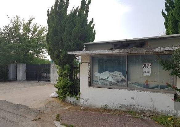 경북 구미산업단지 1공단로에 있는 한 공장부지. 무너질 것 같은 안내소 앞 유리에 ‘공장 신속처리!’라고 적힌 종이 팻말이 붙어 있다. 이 공장부지는 현재 무료 주차장으로 사용되고 있다. /박용선 기자