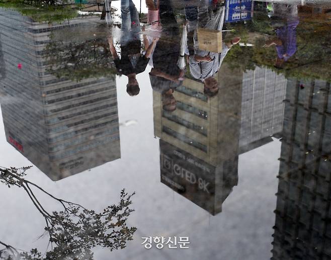 광장 분수대 고인 물에 비친 관광객. /강윤중 기자