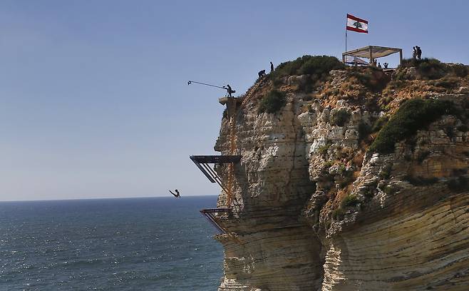 '레드불 클리프 다이빙 월드시리즈' 대회가 열린 레바논 베이루트의 라우체 바다 바위 위에서 14일(현지시간) 한 선수가 절벽아래로 다이빙을 하고 있다. [AP=연합뉴스]