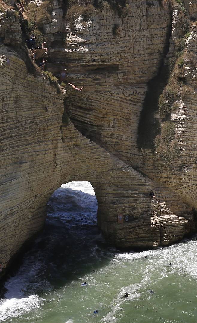 14일(현지시간) 대회에 참가한 선수들이 바위뒷편에서 연습 다이빙을 하고 있다. [AP=연합뉴스]