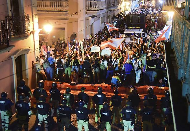 시위대와 경찰이 19일 밤 푸에르토 리코의 산후안에서 대치하고 있다. [AP=연합뉴스]
