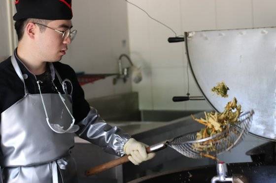 조리병은 높은 계급이 더 힘들고 어려운 임무를 맡는다. 특히 기름 온도가 180℃가 넘어서는 위험한 튀김 요리는 선임병들이 맡는다. 분대장 정민구 상병이 능숙한 솜씨로 야채튀김을 만들고 있다. [사진 박용한]