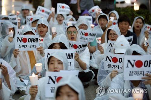 빗속에서의 외침 (서울=연합뉴스) 박동주 기자 = 25일 서울 종로구 주한일본대사관 앞에서 일본제품 불매운동 참가 사연 등을 밝히는 '일본대사관 앞 시민 촛불 발언대' 에서 참가자들이 구호를 외치고 있다. 2019.7.25 pdj6635@yna.co.kr